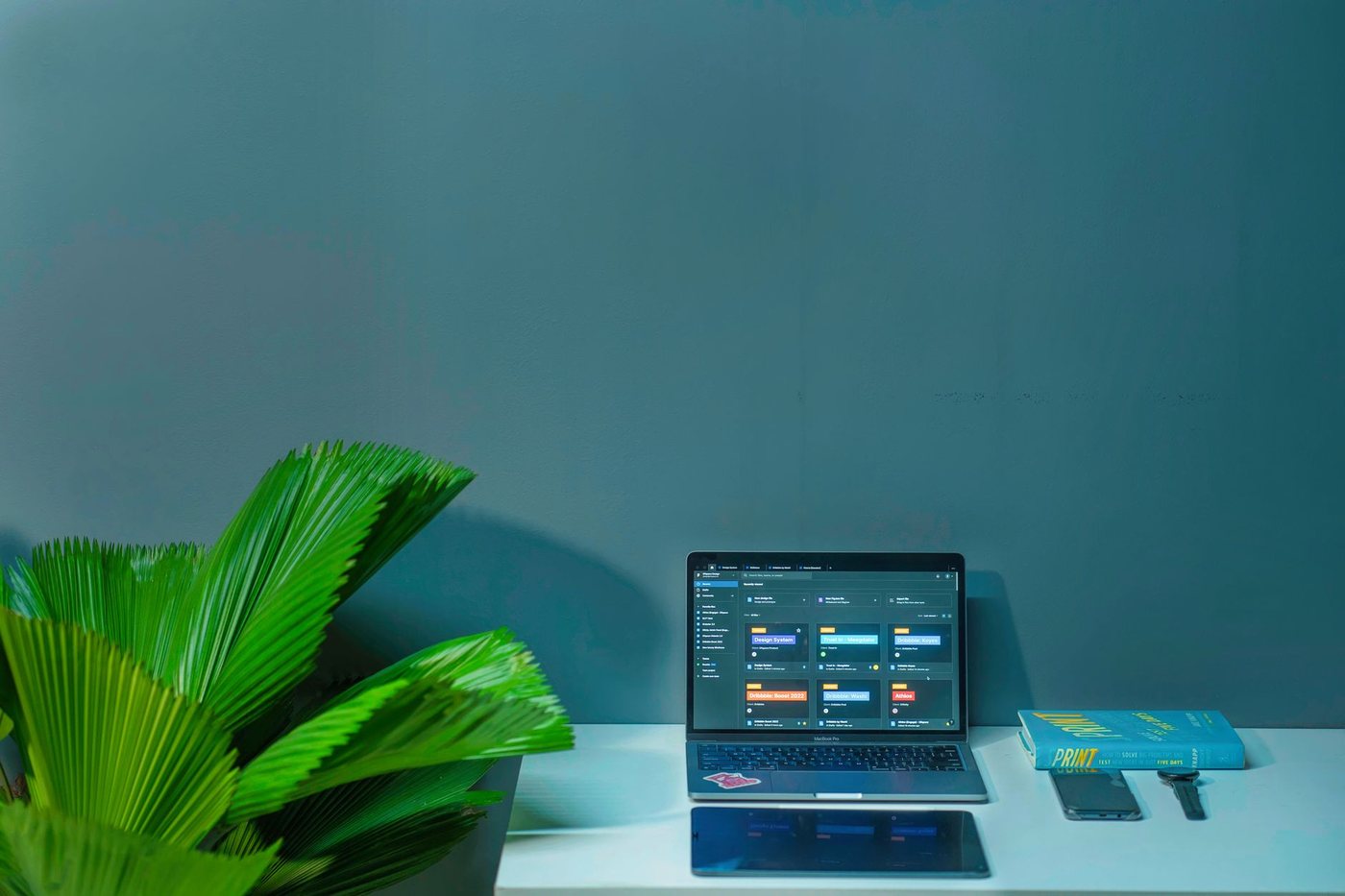 A designer working on a laptop by a window